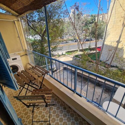 a balcony with two chairs and a railing at Bright, quiet charming getaway ideally located in Jerusalem