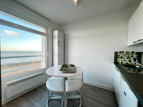 - une cuisine avec une table et une vue sur la plage dans l'établissement COC - Au Large, à Wissant