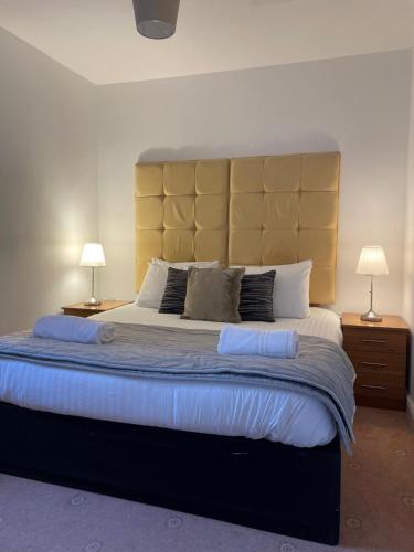 a bedroom with a large bed with two lamps on tables at Ty Bach in Aberystwyth