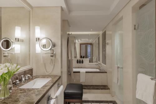 a bathroom with a sink and a shower and a tub at Raffles Makkah Palace in Makkah