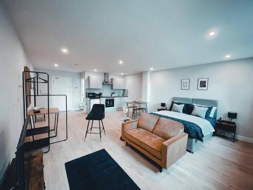 ein Schlafzimmer mit einem Bett und einer Couch in der Unterkunft Market Haven Deluxe Studios Town centre with Netflix, Business & Leisure Travellers in Northampton