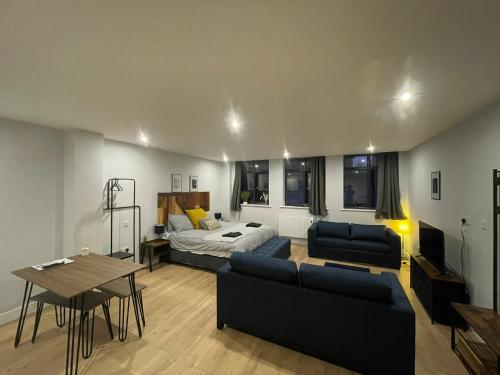 ein Wohnzimmer mit einer Couch, einem Bett und einem Tisch in der Unterkunft Market Haven Deluxe Studios Town centre with Netflix, Business & Leisure Travellers in Northampton