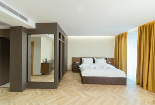 ein Schlafzimmer mit einem Bett und einem großen Spiegel in der Unterkunft La Terrazza Hotel & Restaurant in Hani i Elezit