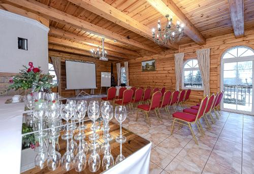 a conference room with a table and chairs and a screen at Bražuolėje Pas Juozą- ramiam poilsiui in Trakai