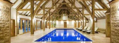 a large swimming pool in a building with wooden ceilings at 6 Berth Mini Lodge at Tydd St Giles Golf and Country Club in Wisbech