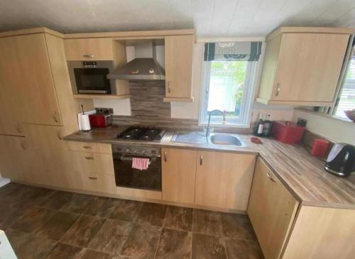 a kitchen with a sink and a stove top oven at 6 Berth Mini Lodge at Tydd St Giles Golf and Country Club in Wisbech
