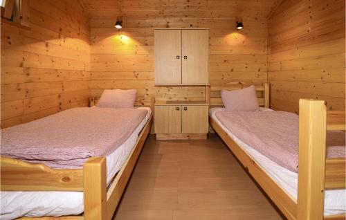 twee bedden in een kamer met houten wanden bij Lovely Home In Sagerberg With Kitchen 