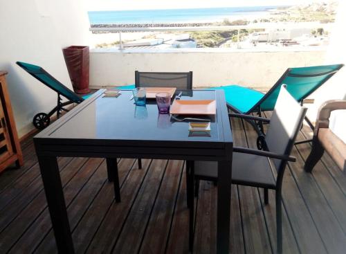 - une table à manger avec des chaises et une vue sur la plage dans l'établissement Duplex 121A, Port nature, au Cap d'Agde