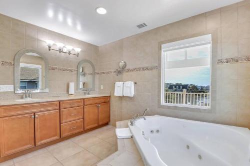 baño grande con bañera y ventana en Luxury 5br Home w Heated Pool Unbeatable Views en Tybee Island