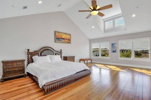 タイビーアイランドにあるLuxury 5br Home w Heated Pool Unbeatable Viewsのベッドと天井扇風機のある寝室