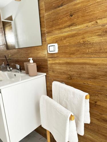 een badkamer met een wastafel, een spiegel en handdoeken bij L’Angolo Degli Dei in Agrigento