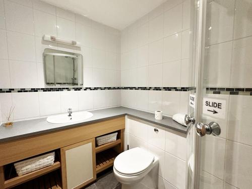 een badkamer met een toilet, een wastafel en een douche bij Surf's Up! in Newquay