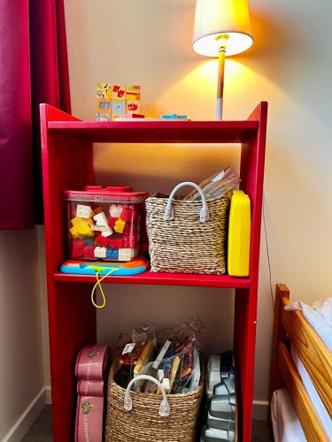 a red shelf with two baskets and a lamp at COC - Basse Mer in Wissant