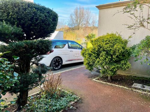 a white car parked in a driveway next to a building at COC - Basse Mer in Wissant