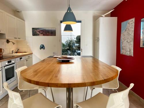 a kitchen with a wooden table and white chairs at COC - Basse Mer in Wissant