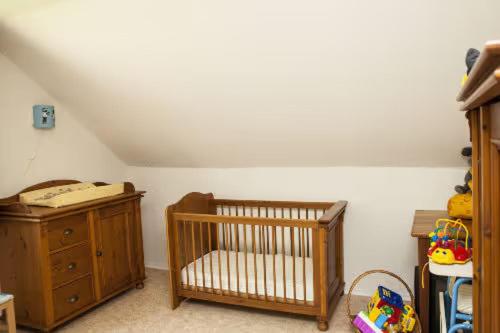 a nursery with a crib and a dresser in a room at Ferienhaus Teufelsmauer in Cattenstedt
