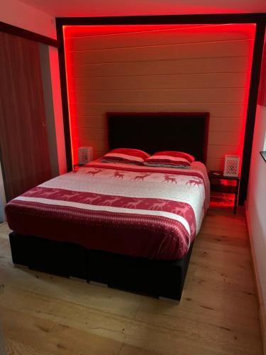 a bedroom with a bed with red lights on it at Riviera Cottage in Comblain-au-Pont