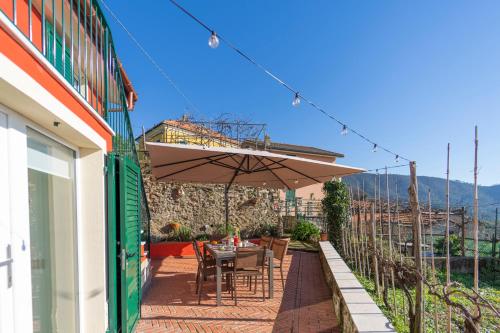 un patio con mesa y sombrilla en B&B La Volpe, en Moneglia