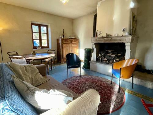 un salon avec un canapé et une cheminée dans l'établissement Petite maison provençale, unique et calme, à Sainte-Jalle
