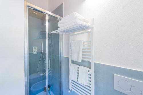 y baño con ducha, paredes azules y toallas blancas. en B&B La Volpe, en Moneglia