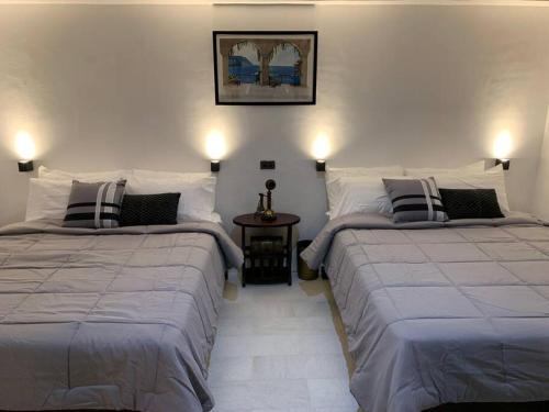 ein Schlafzimmer mit 2 Betten und einem Bild an der Wand in der Unterkunft Paradores Filipinas in Batangas City