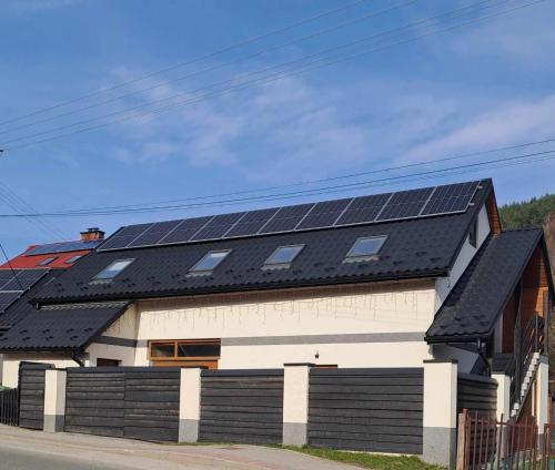 a house with solar panels on the roof at U Beaty, niezależne mieszkania do wynajęcia in Ochotnica Górna
