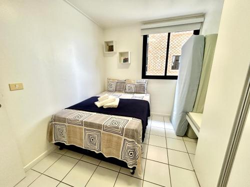 um pequeno quarto com uma cama num quarto em Apartamento Beira Mar de Pajuçara / Maceió em Maceió