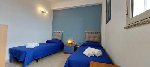 two beds in a room with blue walls at Belvedere Casuzze in Santa Croce Camerina