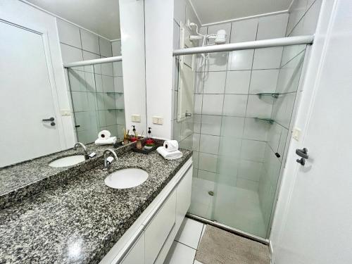 a bathroom with two sinks and a shower at Apartamento Beira Mar de Pajuçara / Maceió in Maceió