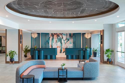 vestíbulo con sofás azules y techo circular en Hotel Landy Orlando Universal Blvd, a Tribute Portfolio Hotel en Orlando