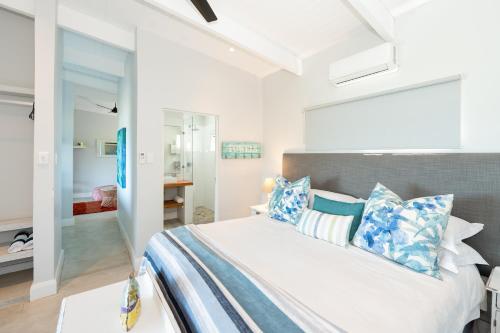 Schlafzimmer mit einem Bett mit blauen und weißen Kissen in der Unterkunft The Beach Bungalow in Durban