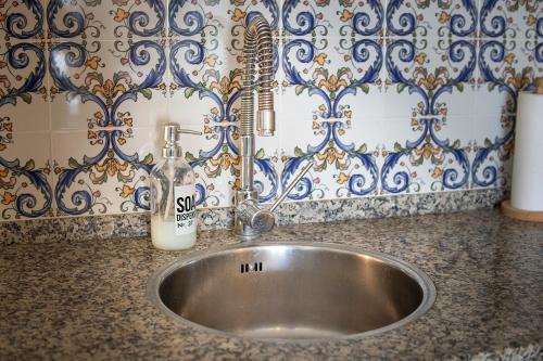 a sink with a soap dispenser on top of it at Casa Marlo, Spacious House in the Lively Centre of Cómpeta in Cómpeta