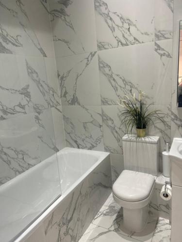 Stylish One Bedroom Apartment in the heart of Angel في لندن: حمام مع مرحاض وحوض استحمام ومغسلة