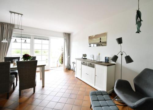 cocina y sala de estar con mesa y sillas en Heidsandschier Hausteil Nordlys, en Witsum