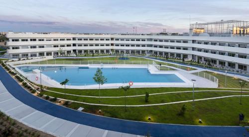 a large building with a large pool in front of it at Student Experience Madrid Pozuelo - Luxury Hostel in Pozuelo de Alarcón