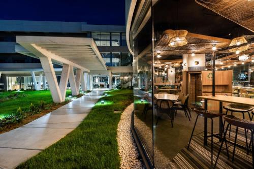 an office building with a grass floor and tables and chairs at Student Experience Madrid Pozuelo - Luxury Hostel in Pozuelo de Alarcón