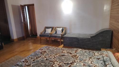 a bedroom with a bed and a couch and a chair at JK's The Trout Stream in Gulmarg