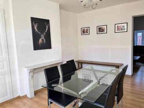 une salle à manger avec une table et des chaises en verre dans l'établissement Grand Duplex* proche Gare*Centre*spacieux, à Dunkerque