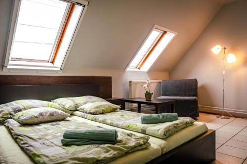 2 Betten in einem Zimmer mit 2 Fenstern in der Unterkunft Aranyhíd Vendégház in Makó
