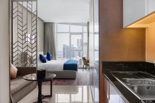 a hotel room with a bed and a living room at New Aparthotel Prive in Dubai