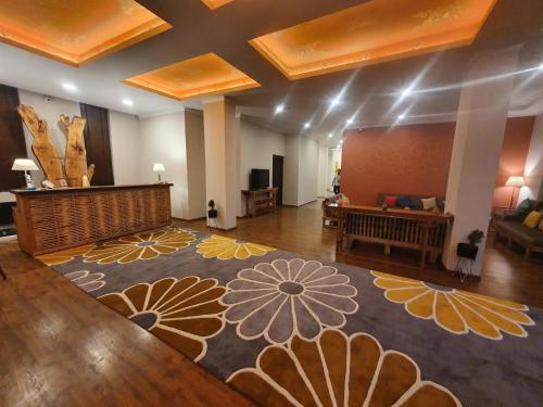 a large room with a stage and a large rug at Hotel Amanthi Ladakh in Leh