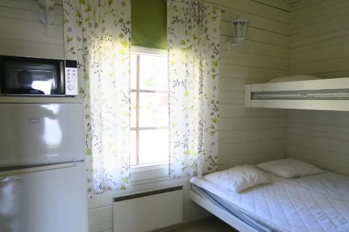 a small room with a bed and a window at Marjoniemi Camping in Hiidenniemi