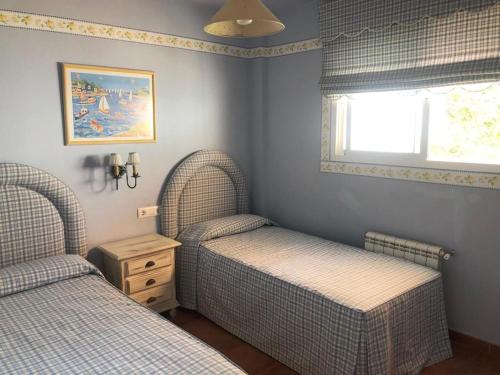 2 camas individuales en un dormitorio con ventana en Villa Bosque Novo Sancti petri Grupo AC Gestión, en Chiclana de la Frontera