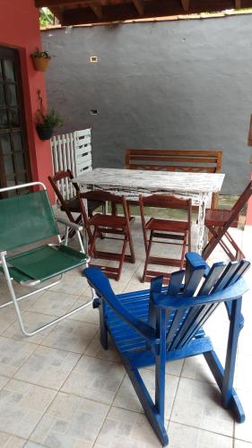 een tafel en stoelen op een patio met een blauwe stoel bij Giorno Hospedaria in São Sebastião