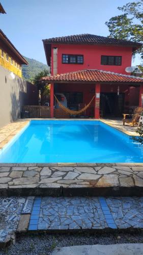 een groot blauw zwembad voor een huis bij Giorno Hospedaria in São Sebastião