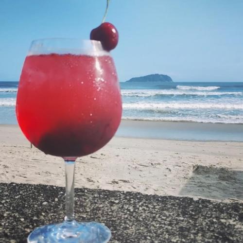 een drankje in een glas zittend op het strand bij Giorno Hospedaria in São Sebastião