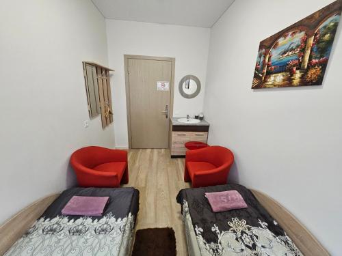 - une chambre avec deux lits et deux chaises rouges dans l'établissement Kambarys centre prie funikulieriaus #4, à Kaunas