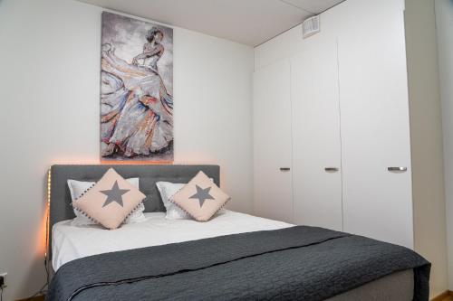 1 dormitorio con 1 cama con una pintura en la pared en Kaksio Helsingissä Autonparkkipaikalla Hyvien Kulkuyhteyksien Varrella en Helsinki