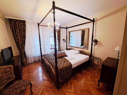 a bedroom with a four poster bed and a mirror at Hotel Livadić in Samobor