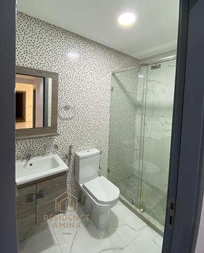 een badkamer met een toilet, een wastafel en een douche bij Résidence Amina in Fnidek